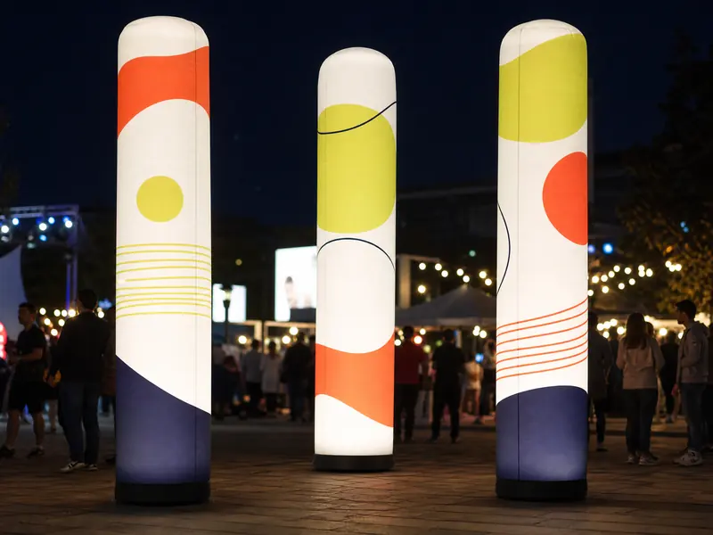 Aufblasbare Leuchtsäulen mit LED-Beleuchtung auf einem Festival bei Nacht